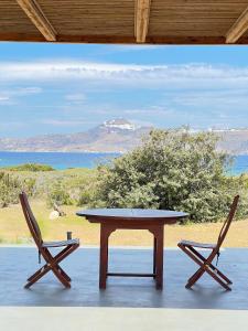 a table and two chairs with a view of the ocean at Villa Serene Milos in Empourios