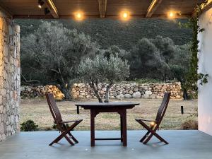 a wooden table and two chairs sitting next to a table at Villa Serene Milos in Empourios