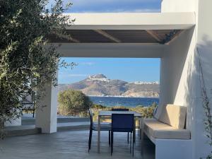 a table and chairs on a patio with a view of the ocean at Villa Serene Milos in Empourios