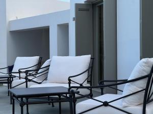 a row of chairs with white pillows in a room at Villa Serene Milos in Empourios