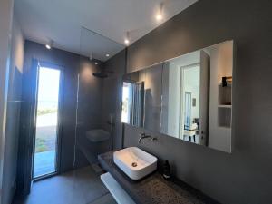 a bathroom with a sink and a mirror at Villa Serene Milos in Empourios