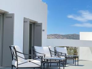 a group of chairs sitting on a balcony with a view at Villa Serene Milos in Empourios