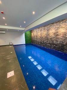 una piscina en una habitación con una pared de ladrillo en Falak Furnished Quarters en ‘Awālī