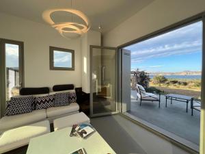 a living room with a couch and a large window at Villa Serene Milos in Empourios