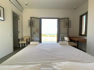 a large white bed in a room with a window at Villa Serene Milos in Empourios