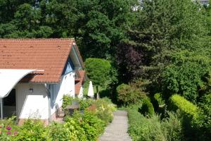 a white house with a red roof next to a garden at Landleben in Fritzlar