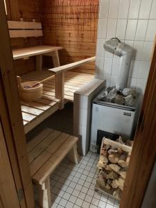eine Küche mit einem Herd, einem Tisch und Bänken in der Unterkunft Mökki Aapola in Puumala