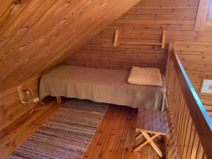 Bett im Dachgeschoss einer Holzhütte in der Unterkunft Mökki Aapola in Puumala