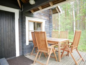 a wooden table and chairs on the porch of a cabin at Mökki Aapola in Puumala