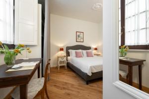 a bedroom with a bed and a table and a desk at Palazzo D'Ambra Residenza d'Epoca in Florence