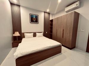 1 dormitorio con 1 cama y armario marrón en MUN HOMESTAY, en Hue