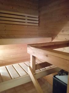 a sauna with a wooden floor and a bed in it at Einonhovi in Ylivieska