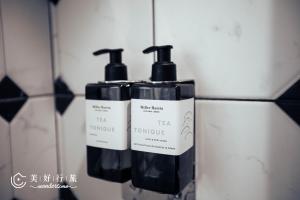 a group of three bottles of soap on a wall at WonderTime2- Ladies' Inn 'Taipei Main Station in Taipei