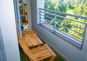 balcón con silla de madera y ventana en Othaya Hideout en Othaya
