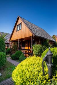 a house with a fire hydrant in front of it at Omega Domki in Gąski