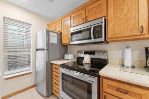 a kitchen with a stove and a microwave at Dog-Friendly Quiet Cove Condo in Hollister