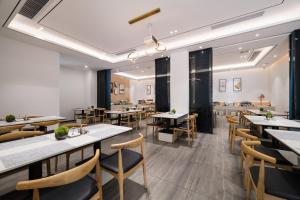 a restaurant with tables and chairs in a room at Paco Hotel Tаojin Metro Guangzhou in Guangzhou