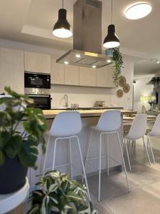 una cucina con sgabelli bianchi e bancone di Bluemoon Apartment a Marsaxlokk