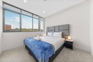 a bedroom with a large bed and two windows at Two Bedroom Private Apartment In Lane Cove with Parking in Sydney