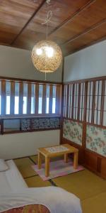 a room with a table in a room with windows at 沼津ライダーハウスしんちゃん in Numazu