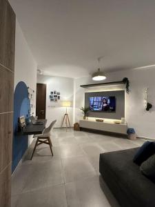 ein Wohnzimmer mit einem Sofa und einem TV an der Wand in der Unterkunft Bluemoon Apartment in Marsaxlokk