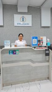 ChepénHotel Jose Ignacio Chepen的坐在商店收银台上的女人