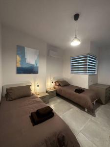 1 Schlafzimmer mit 2 Betten und einem Fenster in der Unterkunft Bluemoon Apartment in Marsaxlokk