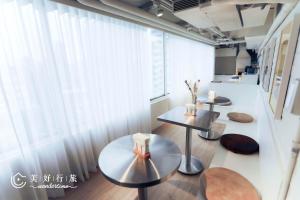 una stanza con due tavoli e una grande finestra di Wondertime Taipei Station - Kaifeng Ladies Hostel a Taipei