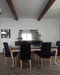 a dining room with a wooden table and chairs at B&BEES in Rocca Ranieri