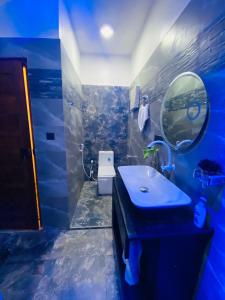 a blue bathroom with a sink and a mirror at Neems paradise in Point Pedro