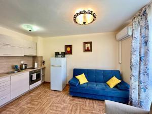 a living room with a blue couch in a kitchen at Apartment Monica in Sveti Vlas