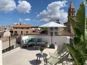 um pátio com cadeiras e um guarda-sol no telhado em Boutique Hotel Petit Montisión em Palma de Maiorca