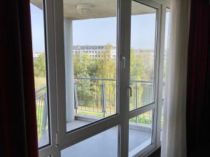 ein offenes Fenster mit Blick auf einen Balkon in der Unterkunft SleepBEEONE AIRPORTHOTEL FRANKFURT MÖRFELDEN in Mörfelden-Walldorf