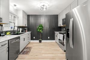 亚特兰大Opulent Haven Retreats的厨房配有白色橱柜和不锈钢冰箱