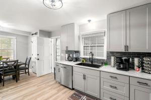 a kitchen with white cabinets and a dining room at Opulent Haven Retreats in Atlanta