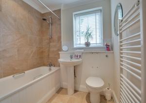 een badkamer met een wastafel, een toilet en een bad bij Pebblesea in Whitstable