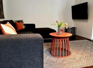 a living room with a table with a vase of flowers on it at Apartments "Am Rheinorange", Netflix, Amazon Prime in Duisburg