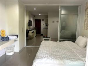 a bedroom with a large white bed and a bathroom at Condo Joe in Central Hua Hin in Hua Hin