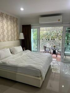 a bedroom with a large bed and a balcony at Condo Joe in Central Hua Hin in Hua Hin
