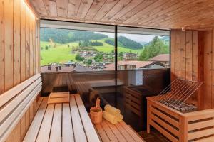 an inside view of a wooden cabin with a large window at Adler Resort in Saalbach-Hinterglemm