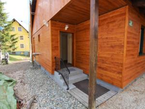 a wooden building with a porch and a staircase at Sunlit Cabin with Jacuzzi in Turracherhohe in Turracher Hohe