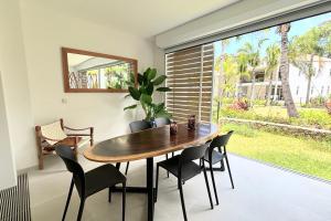 a dining room with a table and chairs and a window at GAIA Lodge seaside in Paea