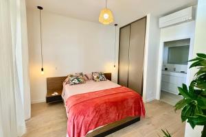 a bedroom with a bed with a red blanket at GAIA Lodge seaside in Paea