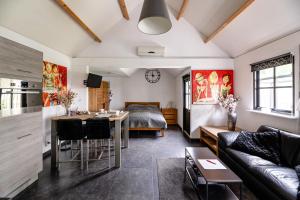 a living room with a bed and a dining room at Brabants Genieten in Kaatsheuvel