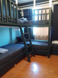 a bunk bed and a couch in a room at De Leon Staycation at Vista de Loro in Ternate +37 photos