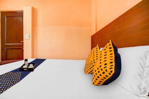 a bed with two polka dot pillows on it at SPOT ON Hotel New Style in Zirakpur