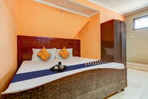 a bedroom with a large bed with orange walls at SPOT ON Hotel New Style in Zirakpur