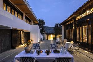 a table with a vase on it next to a building at 音糖Museum雪山森系隐奢艺术庄园 丽江束河古镇店 in Lijiang