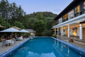 a swimming pool in front of a building at 音糖Museum雪山森系隐奢艺术庄园 丽江束河古镇店 in Lijiang