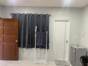 um quarto com uma cortina de chuveiro preta e uma porta em สวนชะลอม em Ban Ton Chuak